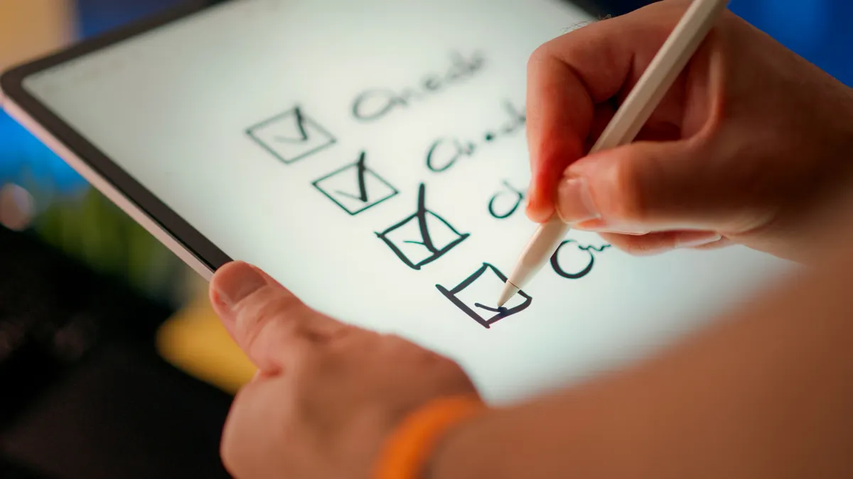 hand checking boxes on a touchscreen checklist