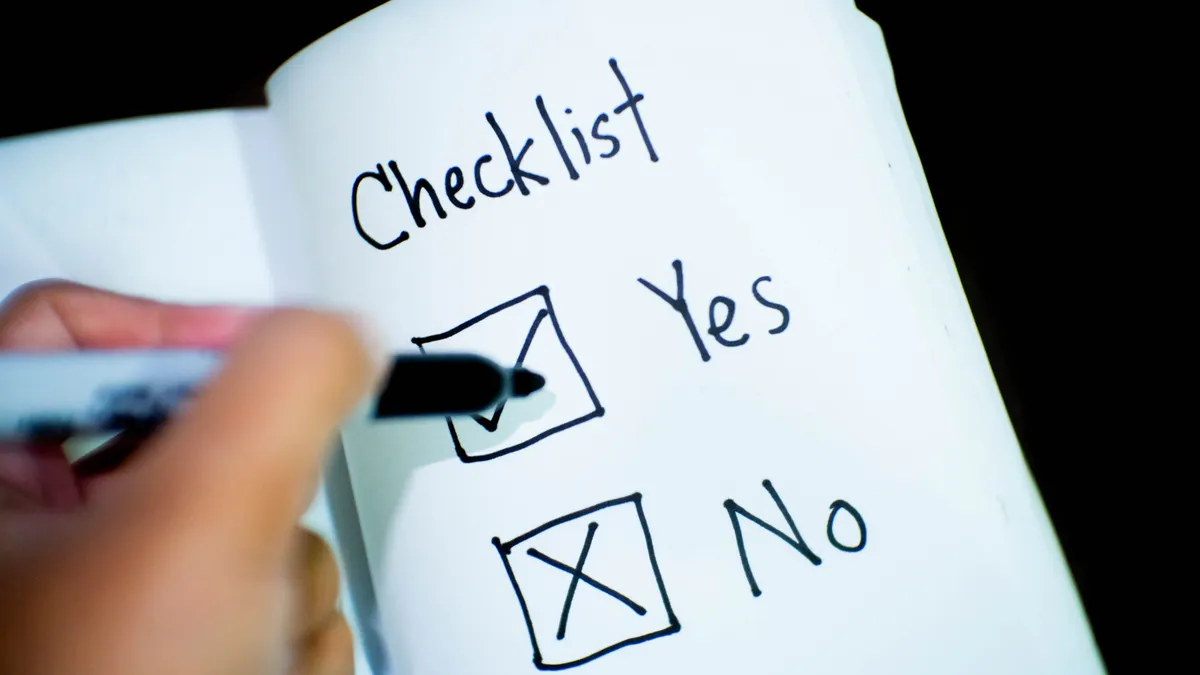 hand marking yes/no checklist in a notebook
