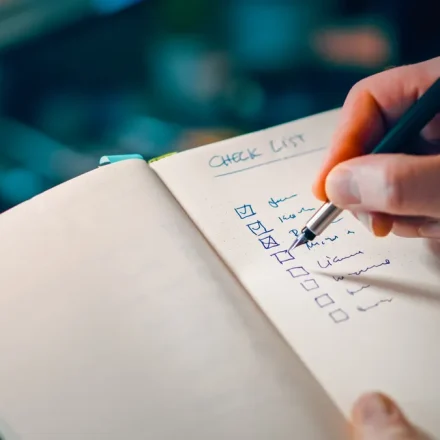hand writing on a checklist in a notebook