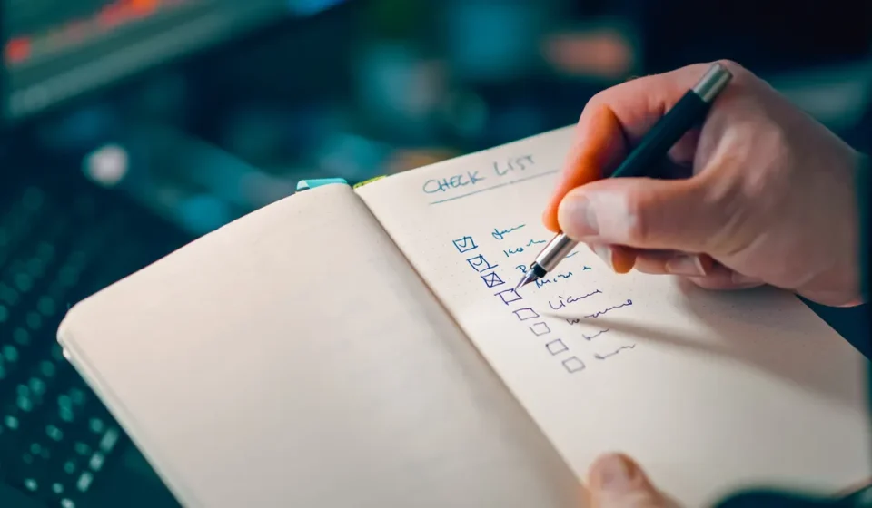 hand writing on a checklist in a notebook